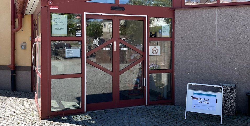 Utanför Boxholms kommunhus med en skylt där det står att här kan du rösta.